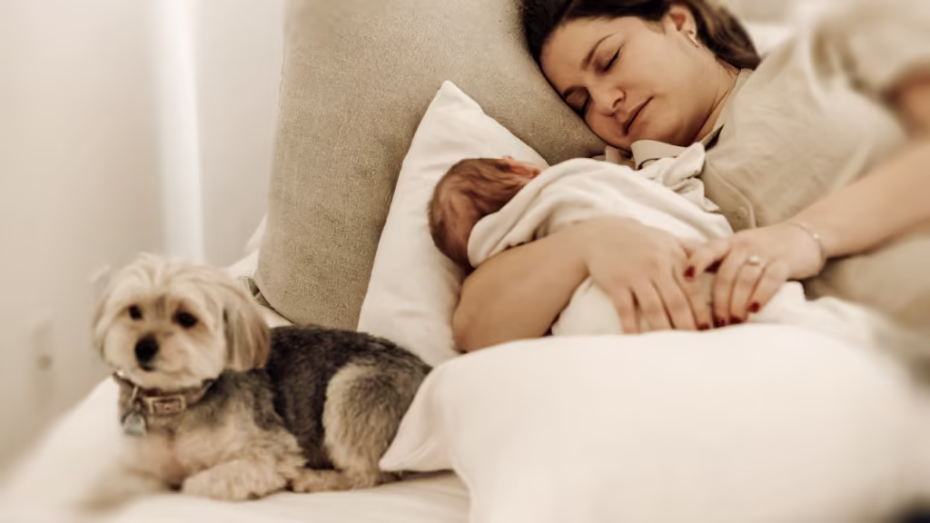 En bebis sover tätt intill sin mamma, en lugn stund under utvecklingssprång vecka 5 då närhet och trygghet är extra viktigt för barnets utveckling.